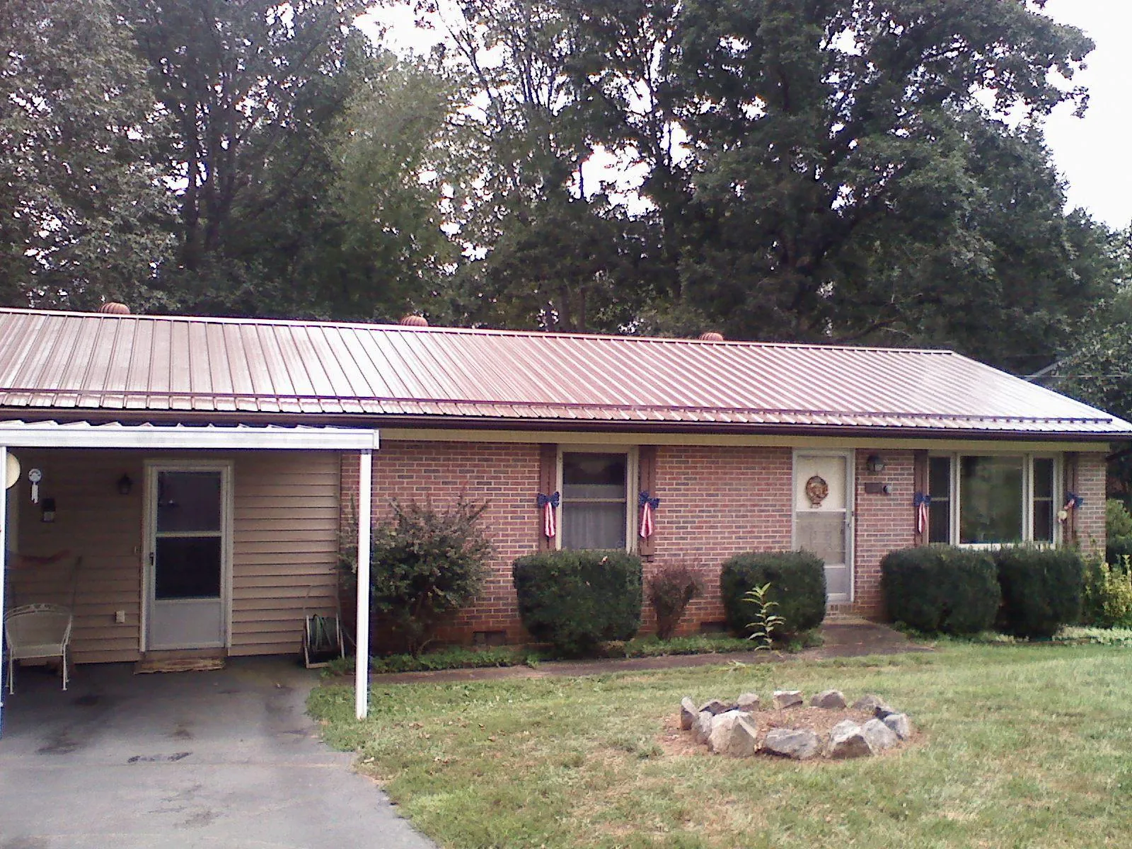 Bronze metal roof and carport on a brick ranch home — Roof Repair work by our crew in Picacho